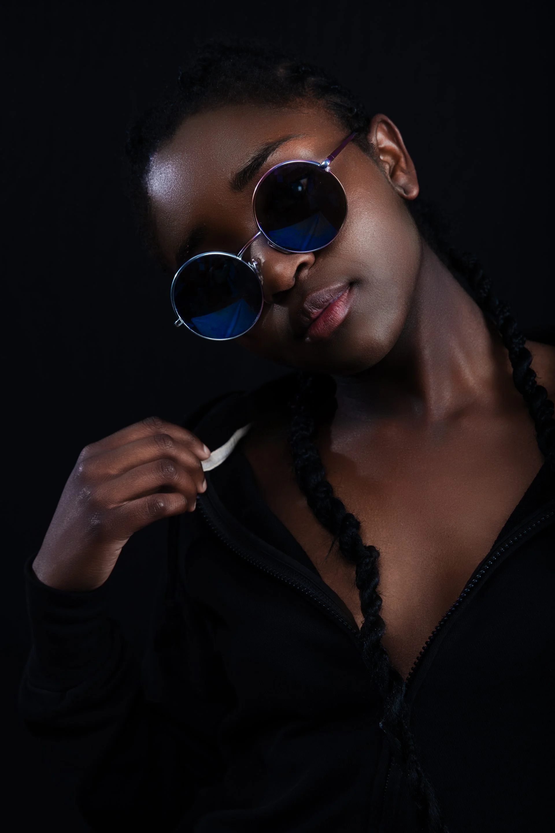 Cool woman with dark skin wearing round sunglasses