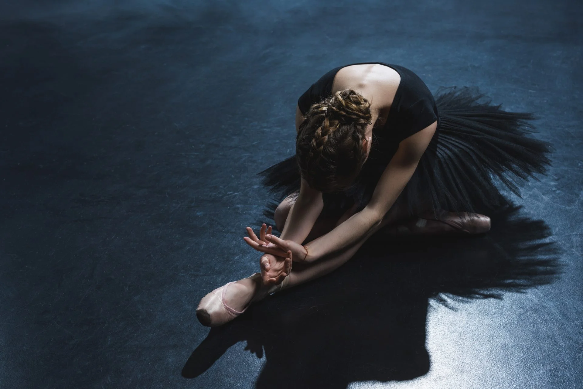 elegant ballet dancer in pointe shoes and black tutu in studio