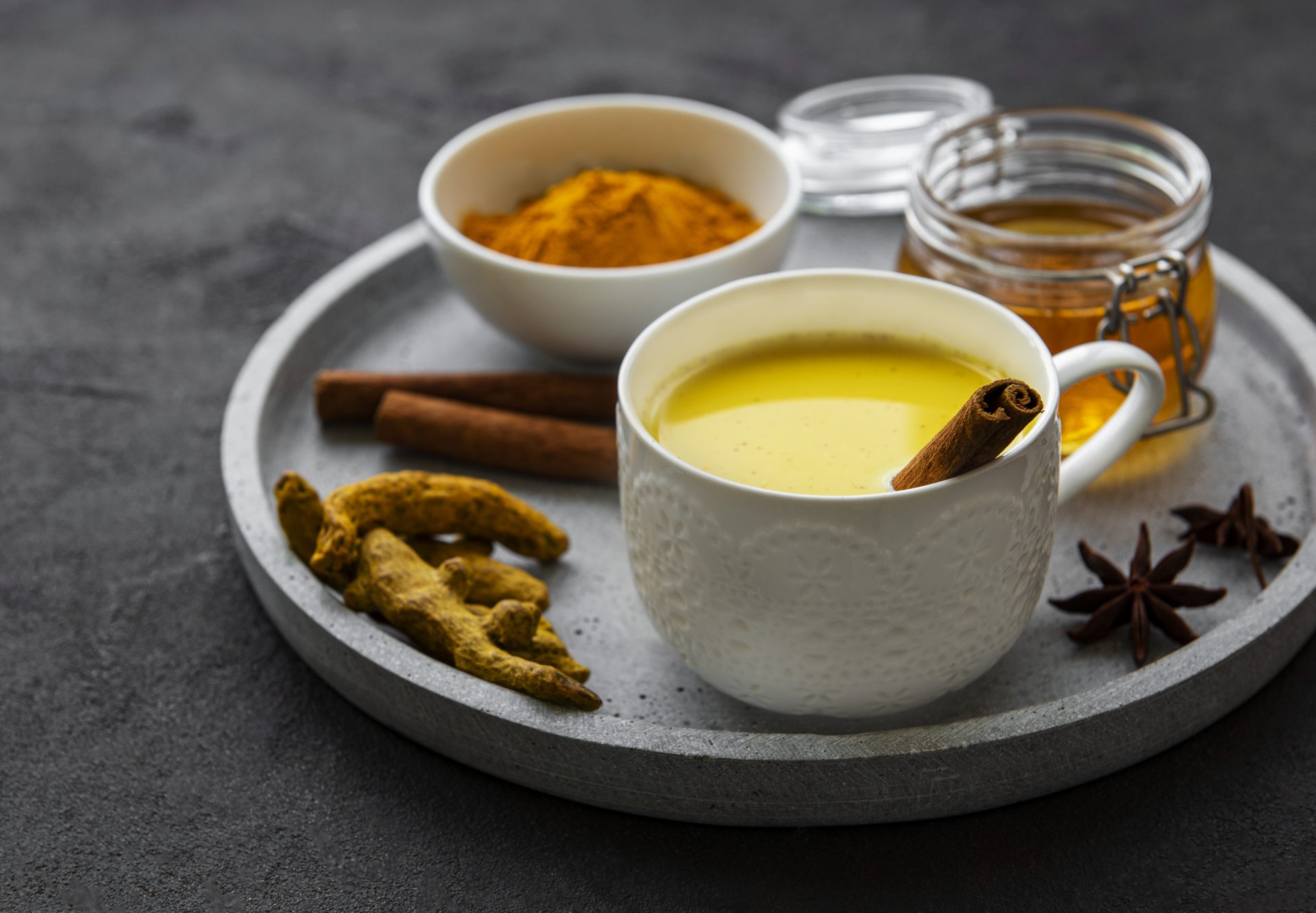 Yellow turmeric latte drink. Golden milk with cinnamon, turmeric