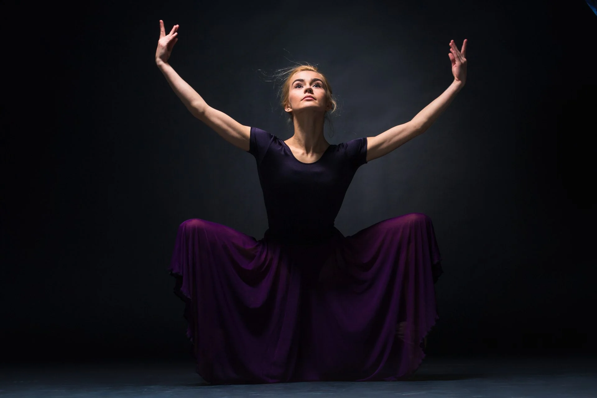 Young beautiful modern style dancer posing on a studio background