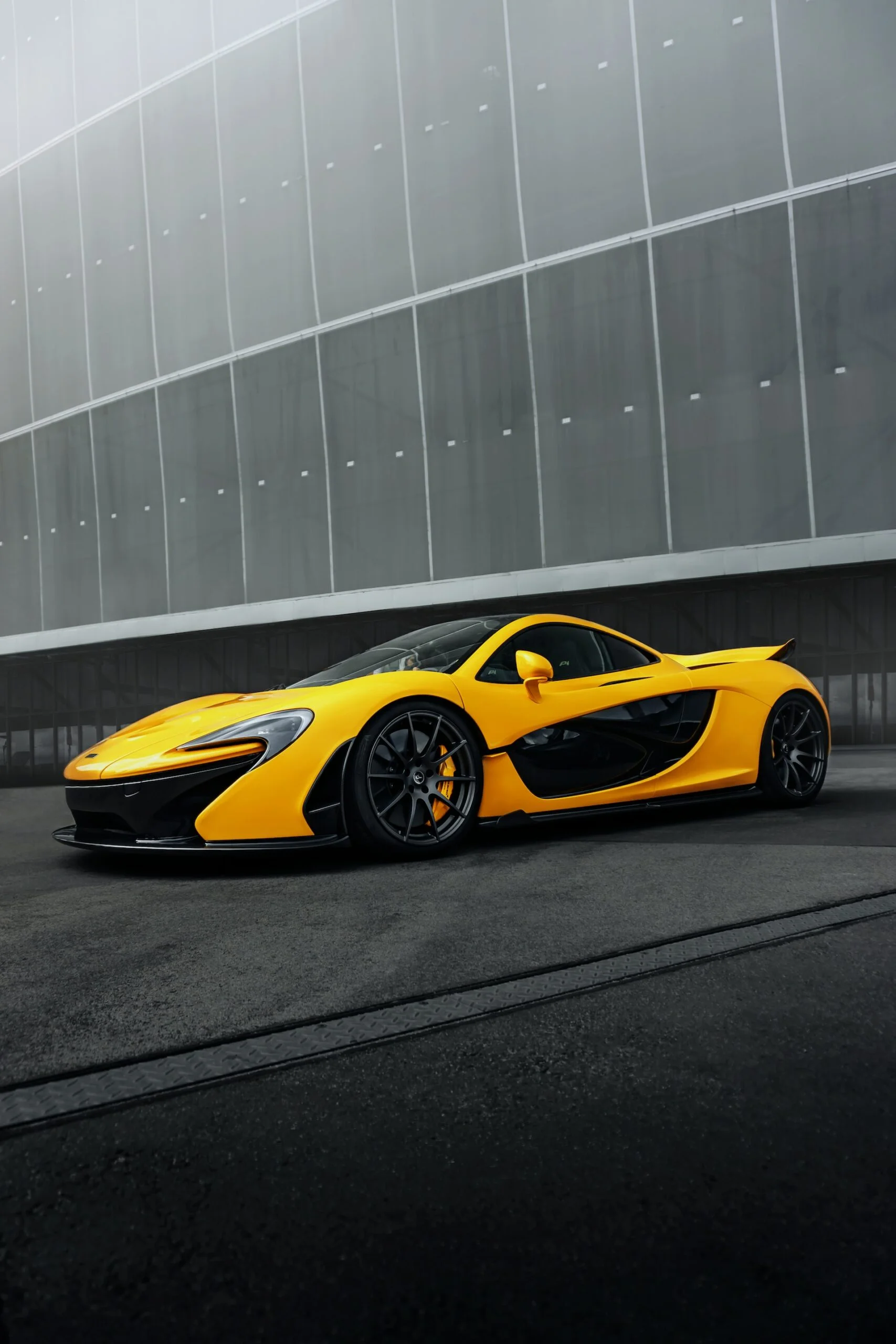 Yellow sports car parked in front of a building