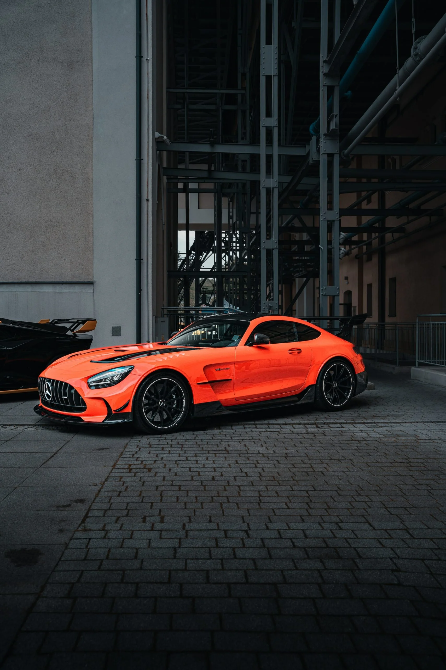 Orange sports car parked in front of a building