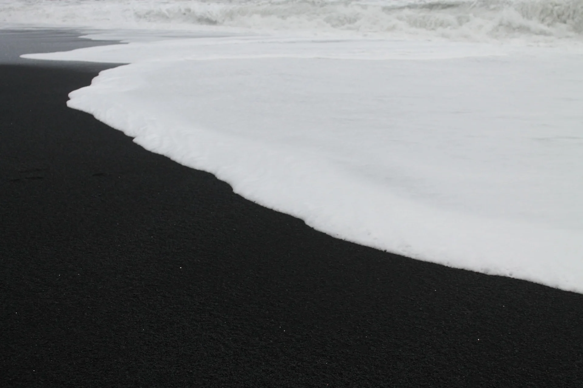 Black sand beach with waves coming in
